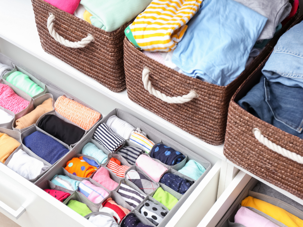 A closet full of clothes in organizing baskets.
