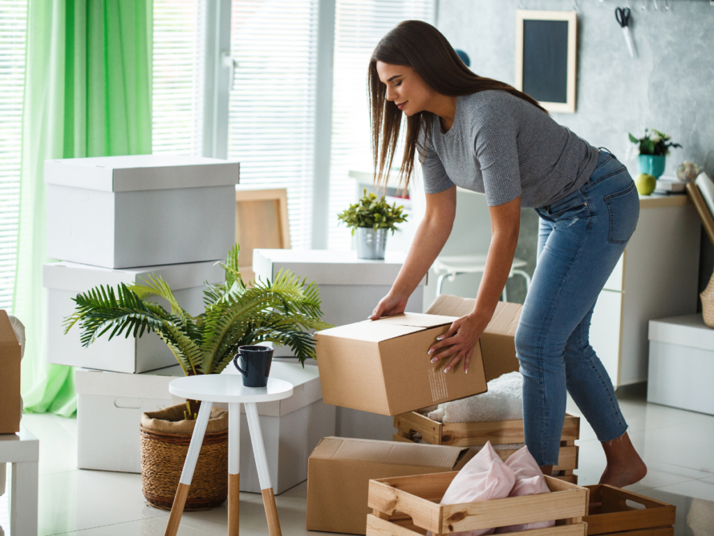 A woman unpacking boxes in her new home to avoid organizing mistakes.